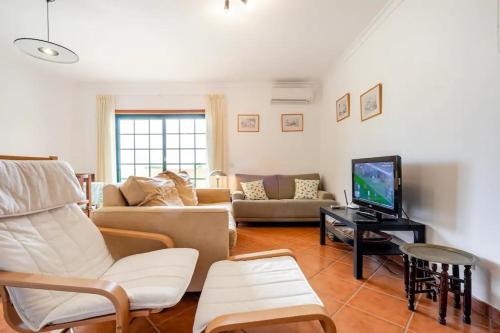 a living room with a couch and a tv at Apartamento Parque Ria Formosa, Olhão in Olhão