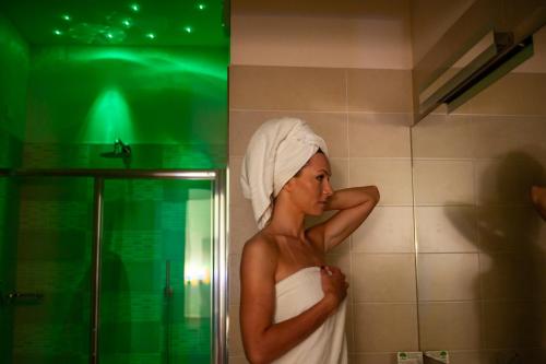a woman with a towel on her head standing in a bathroom at SmArt Hotel Bartolini in Montecatini Terme