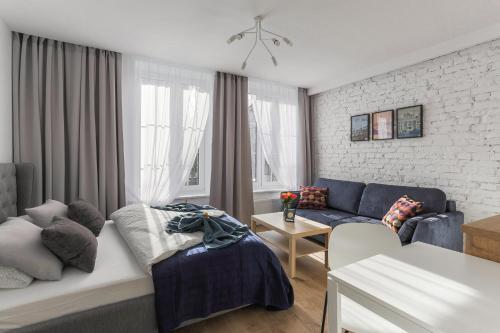 - un salon avec un lit et un canapé dans l'établissement Central Apartments Piwna, à Gdańsk