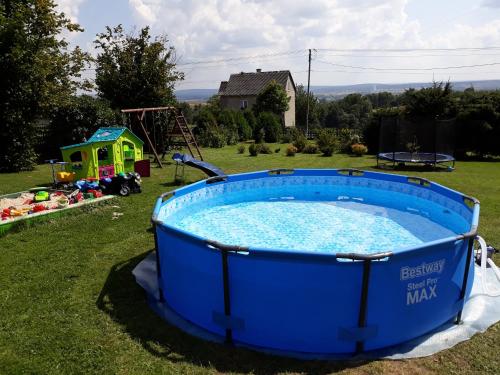 a large blue tub in a yard with a playground at Agroturystyka Skrzeczówka in Krajno Pierwsze