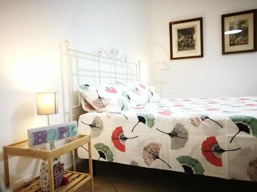 a bedroom with a bed with a comforter and a table at Appartamento Da Vinci in Monticelli Terme