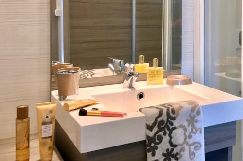 bagno con lavandino bianco e specchio di Les Suites De Pertamina a Bonifacio