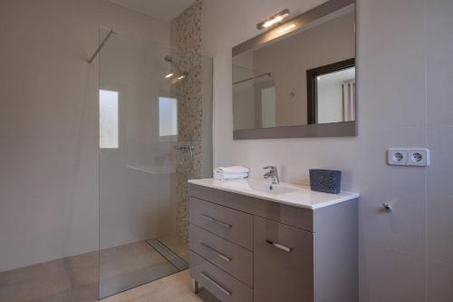 a bathroom with a sink and a shower with a mirror at Villa Paz in Benissa