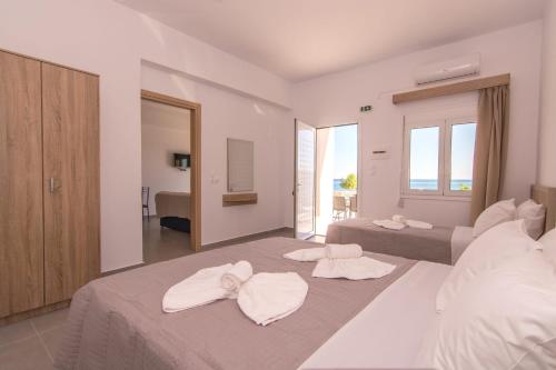a hotel room with two beds with towels on them at Votsalo Studios & Apartment in Frangokastello