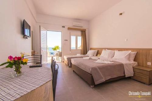 een hotelkamer met 2 bedden en een balkon bij Votsalo Studios & Apartment in Frangokastello