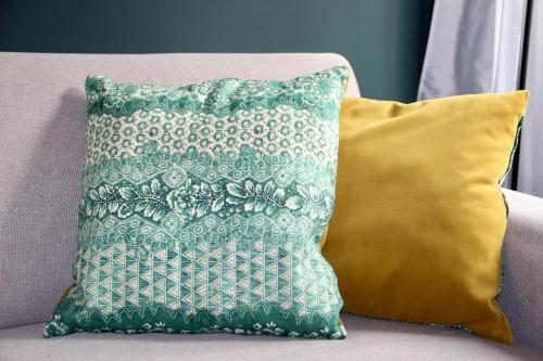 a green pillow sitting on a couch with a yellow pillow at Laguna Boutique Apartments in Mestre