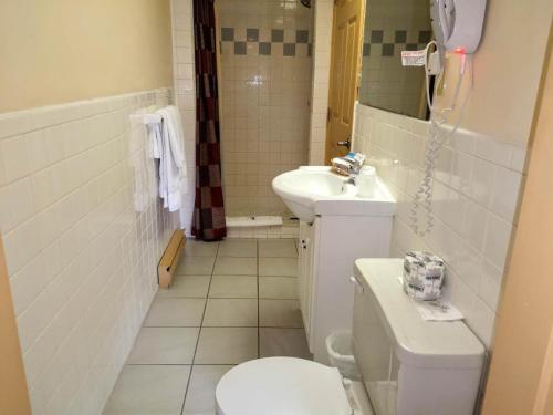 a bathroom with a toilet and a sink at Hotel Motel La Marquise in Sherbrooke