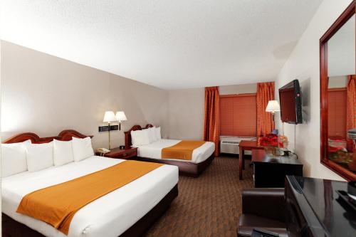 a hotel room with two beds and a flat screen tv at The Niobrara Lodge in Valentine