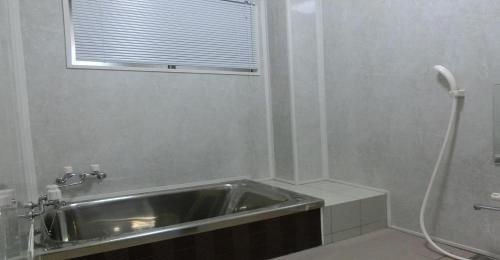 La salle de bains est pourvue d'un lavabo et d'une fenêtre. dans l'établissement Ryokan Suzukisou-Single room No bath and toilet - Vacation STAY 17861, à Kyoto