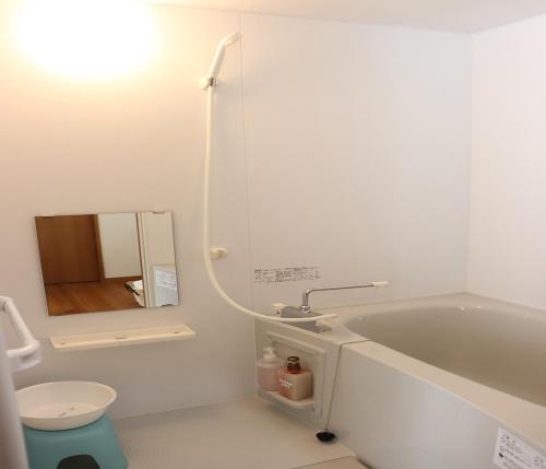 a bathroom with a tub and a toilet and a sink at The Hirosawa City Dome House West Building / Vacation STAY 18763 in Chikusei