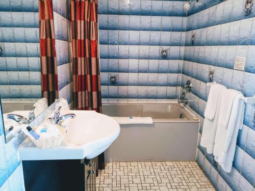 a bathroom with a sink and a bath tub at Hotel Motel La Marquise in Sherbrooke