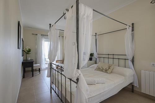a bedroom with a canopy bed with white curtains at Villa Anuska - Plusholidays in Calpe