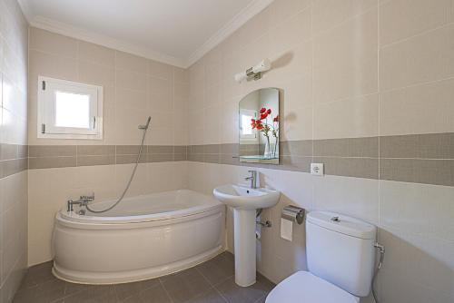 a bathroom with a sink and a tub and a toilet at Villa Anuska - Plusholidays in Calpe