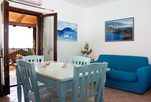 a dining room with a table and a blue couch at Residence Il Casale in Palinuro