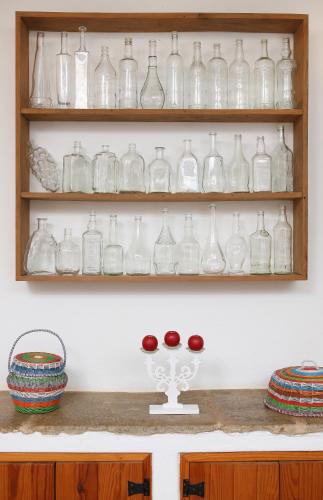 a shelf filled with lots of glass bottles at Monte das Cortelhas in Guia