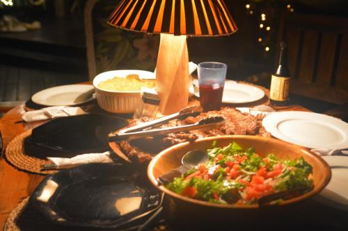 a table with a bowl of food and a lamp at TreeTops Inn in San Juanillo