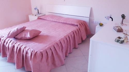 1 dormitorio con 1 cama rosa y 2 almohadas en Casa vacanze Cilento, en Torraca