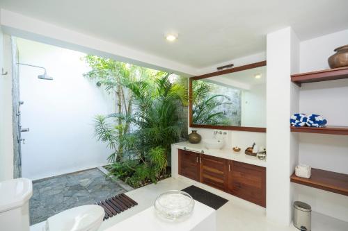 a bathroom with a sink and a mirror at Garden Villa Ronnaduwa in Hikkaduwa