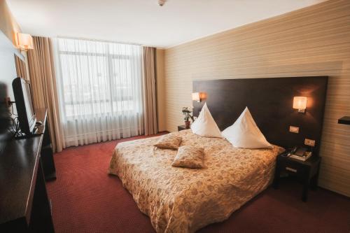 una habitación de hotel con una cama con almohadas. en Hotel EMD, en Bacău