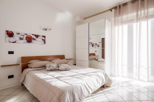 une chambre blanche avec un lit et une grande fenêtre dans l'établissement Your Holiday in Bologna, à Bologne