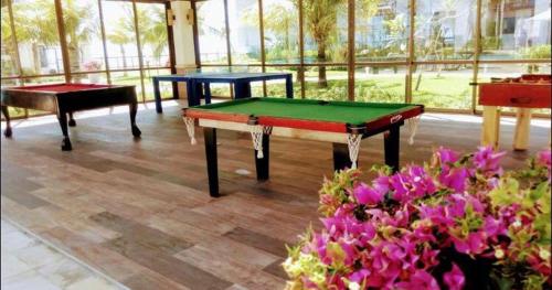 three ping pong tables in a room with flowers at Wai Wai Cumbuco Eco Residence in Cumbuco