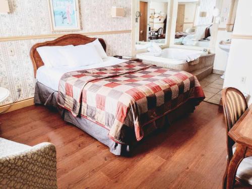 a bedroom with a bed and a bathroom with a sink at Hotel Motel La Marquise in Sherbrooke