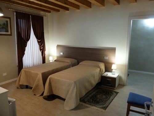 a bedroom with two beds and a window at B&B Eldorado in Sommacampagna
