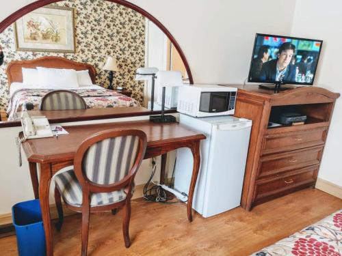 a bedroom with a desk with a bed and a computer at Hotel Motel La Marquise in Sherbrooke
