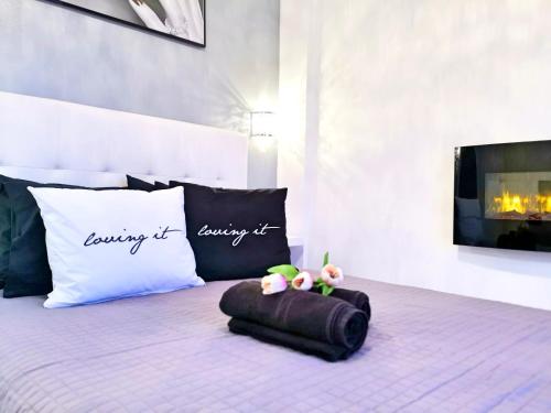 a bed with a pillow and two stuffed animals on it at Pure BLISS Luxury Beachfront Apartment with Panoramic Sea Views, Electric BBQ, Gym Equipment and More in Agia Triada