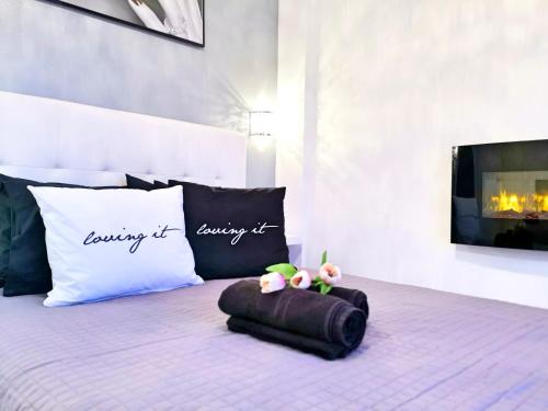 a bed with a pillow and two stuffed animals on it at Pure BLISS Luxury Beachfront Apartment with Panoramic Sea Views, Electric BBQ and More in Agia Triada
