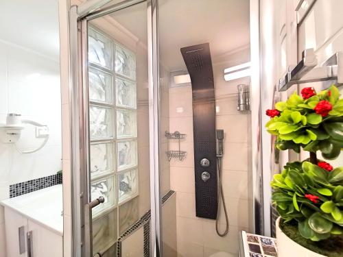 a shower with a glass door next to a window at Pure BLISS Luxury Beachfront Apartment with Panoramic Sea Views, Electric BBQ, Gym Equipment and More in Agia Triada