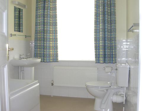 Łazienka z białą toaletą i umywalką w obiekcie Stavordale House w mieście Weymouth