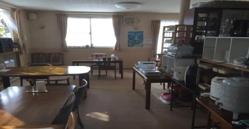 Myoko - Hotel / Vacation STAY 17055 في ميوكو: غرفة بها طاولات وكراسي ونافذة
