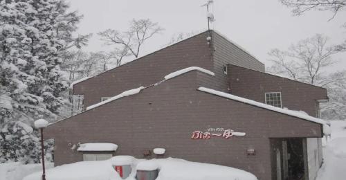 un bâtiment recouvert de neige sur le toit dans l'établissement Myoko - Hotel / Vacation STAY 17051, à Myōkō