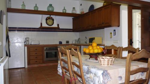 a kitchen with a table with a bowl of fruit on it at Can Gat in Sant Carles de Peralta