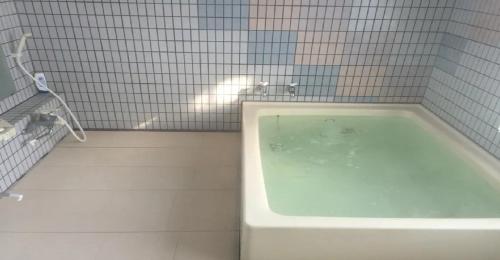 a bath tub in a bathroom with white tiles at Myoko - Hotel / Vacation STAY 17051 in Myoko