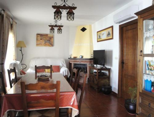 Una sala de estar con una mesa y una chimenea. en Casa El Paseo, en Arriate