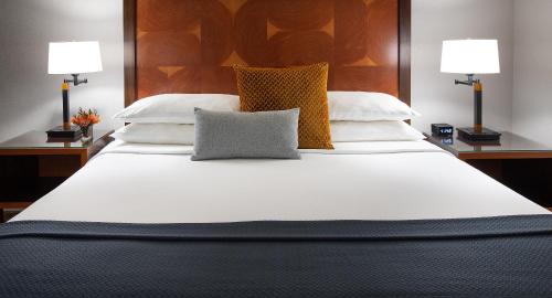 a large white bed with two pillows on it at The Paramount Hotel Portland in Portland