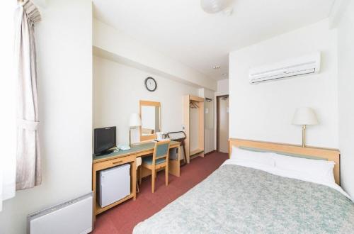 a bedroom with a bed and a desk with a television at Nagoya - Hotel / Vacation STAY 19141 in Nagoya