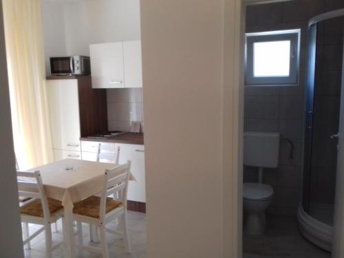 Il comprend une petite cuisine avec une table et des toilettes. dans l'établissement Apartmani Goran Orebić, à Orebić