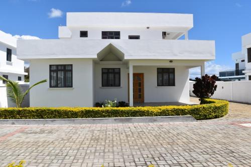 a white house with a brick driveway at Brighthelm Villas in Pereybere