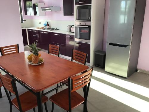 a kitchen with a wooden table with a pineapple on it at Brighthelm Villas in Pereybere