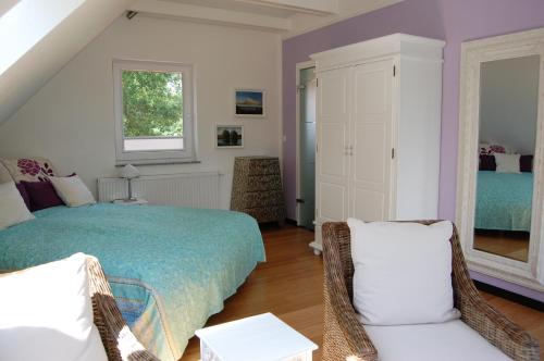 a bedroom with a bed and two chairs at Landhaus Tönning in Damp