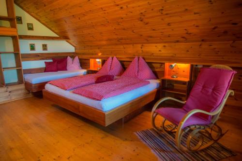 a bedroom with two beds and a chair in a cabin at Bauernhofferien Oberdürnberg in Seekirchen am Wallersee