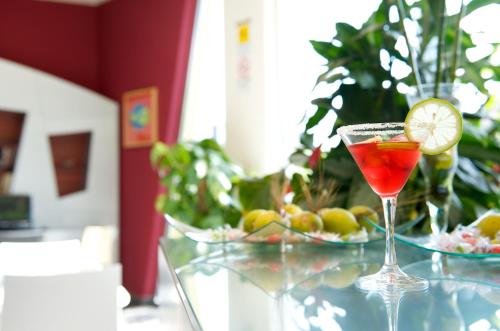 a drink in a martini glass with a lime on a table at ibis Styles Catania Acireale in Acireale