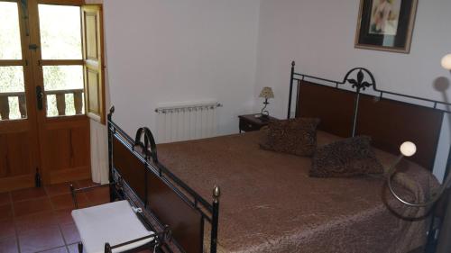 a bedroom with a large bed with a wooden frame at Can Gat in Sant Carles de Peralta