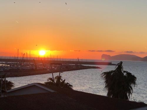 a sunset over a body of water with a pier at Appartamento Francesca in Alghero