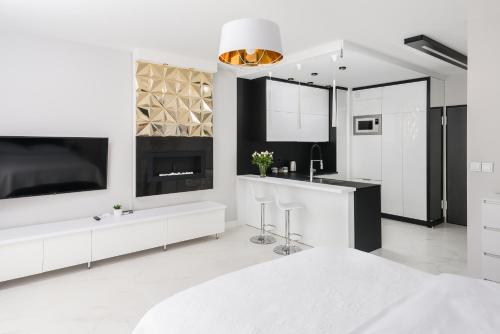 a white kitchen with a large tv and a counter at Dream4You Apartments in Wrocław