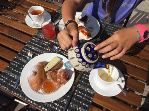 - une table avec deux assiettes de nourriture et une théière dans l'établissement Hotel Ariston ***S, à Madonna di Campiglio