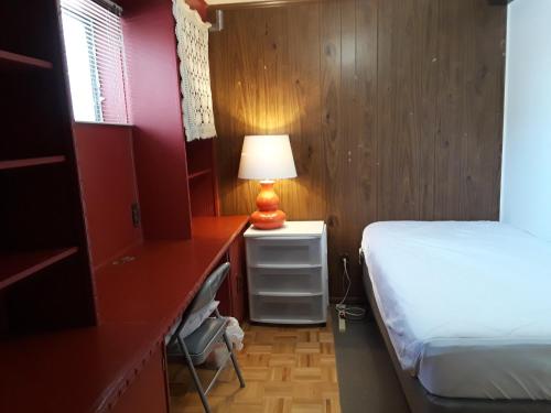 a bedroom with a bed and a lamp on a desk at Private Room near Airport in Mississauga